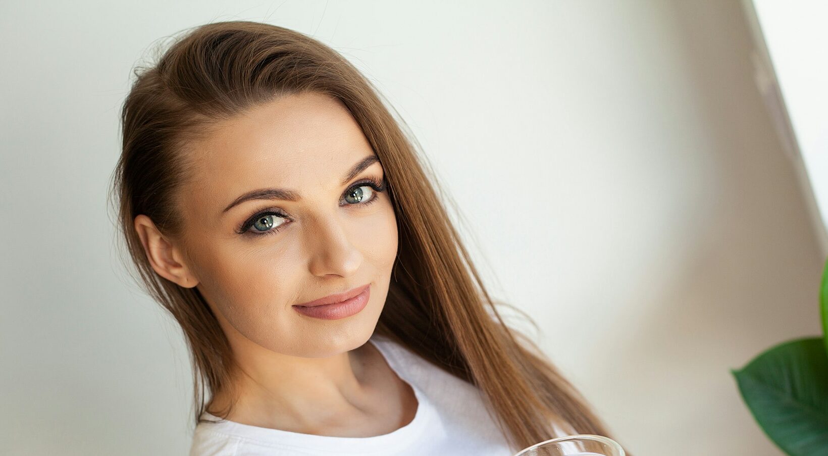 Beautiful youthful lady refreshing herself with lemon water