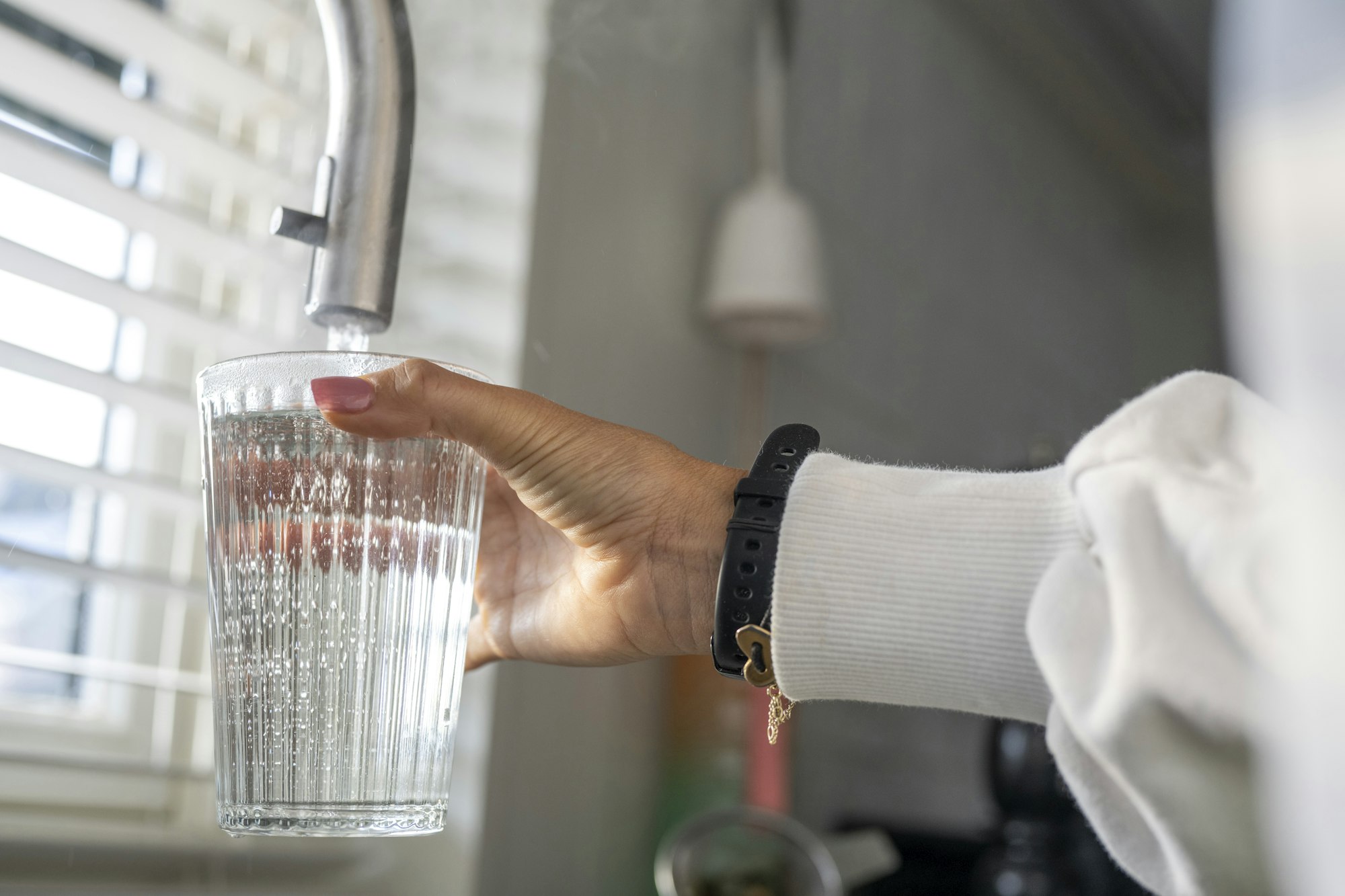 Lady filling her glass with fresh clean water